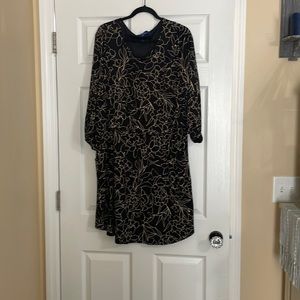 Women’s black dress with beige floral accents.